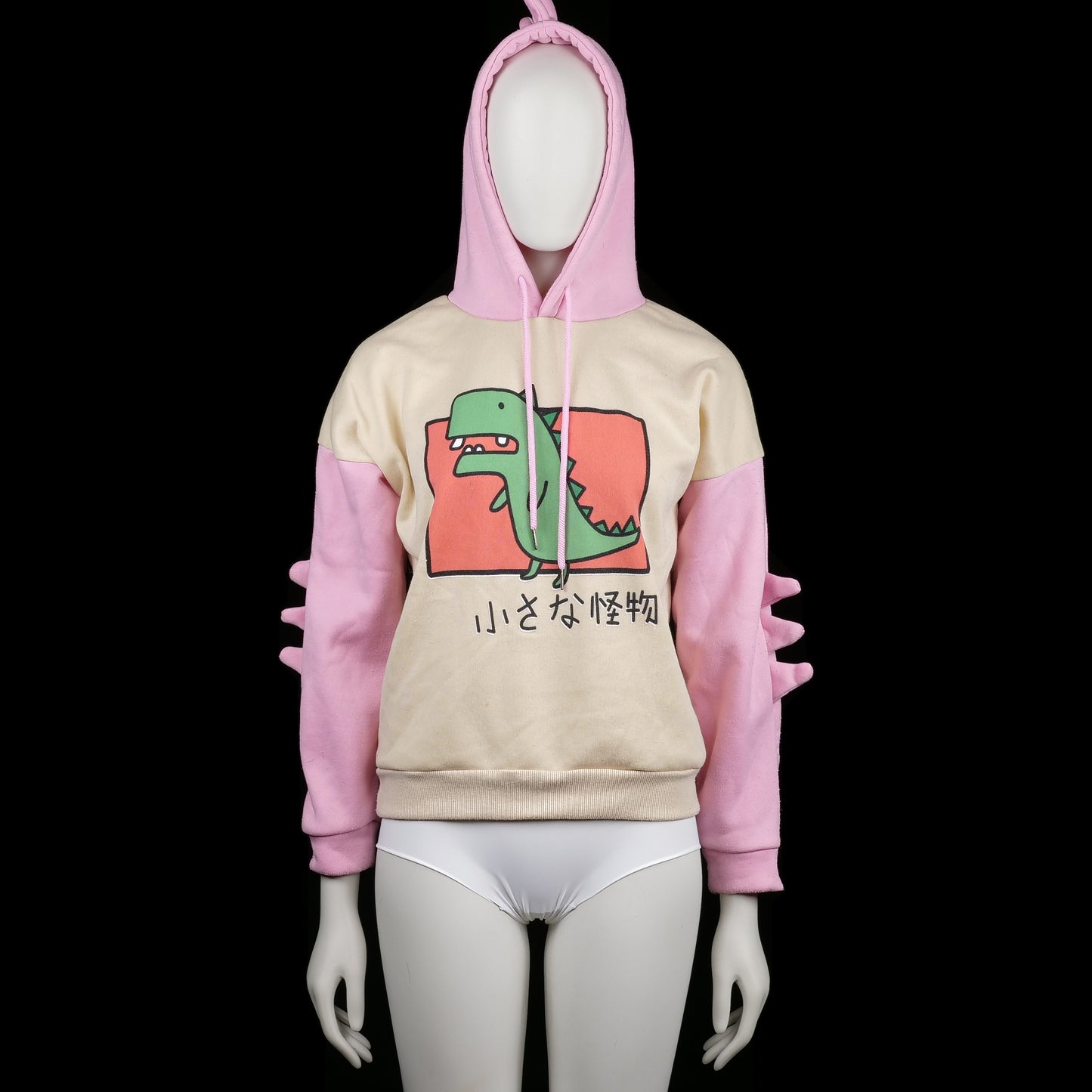 Hoodie - Ivory & Pink - Size S - Two-tone hoodie with ivory body and pink sleeves, featuring a green cartoon dinosaur print on the front and Japanese text. Hood has pink spikes on top and sleeves have matching 3D spike detailing.