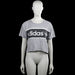 Adidas - T-shirt - Light Gray & Black - Size 32 - Light gray short-sleeve T-shirt with a round neck and straight hem. Black chest panel with white stripes and a large white text graphic on the front.