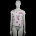 S.oliwen - T-shirt - White & Pink - Size 36 - White top with a floral pattern in pink, blue, and green, featuring a wide boat neckline and short sleeves. Straight hem with a back cutout and crisscross strap detail.