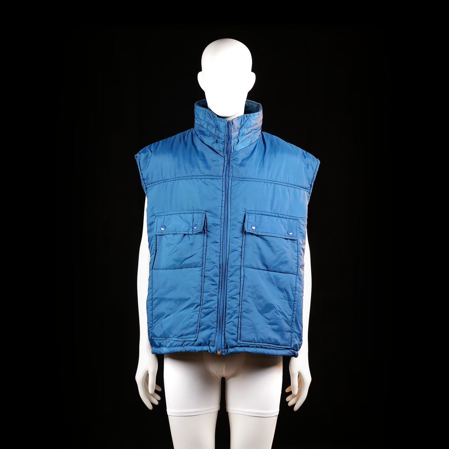 Masterpiece Apparel - Padded vest - Denim Blue - Size 2XL - Sleeveless padded vest with a high stand collar and front zipper closure. Features two large flap pockets with snap buttons on the front.