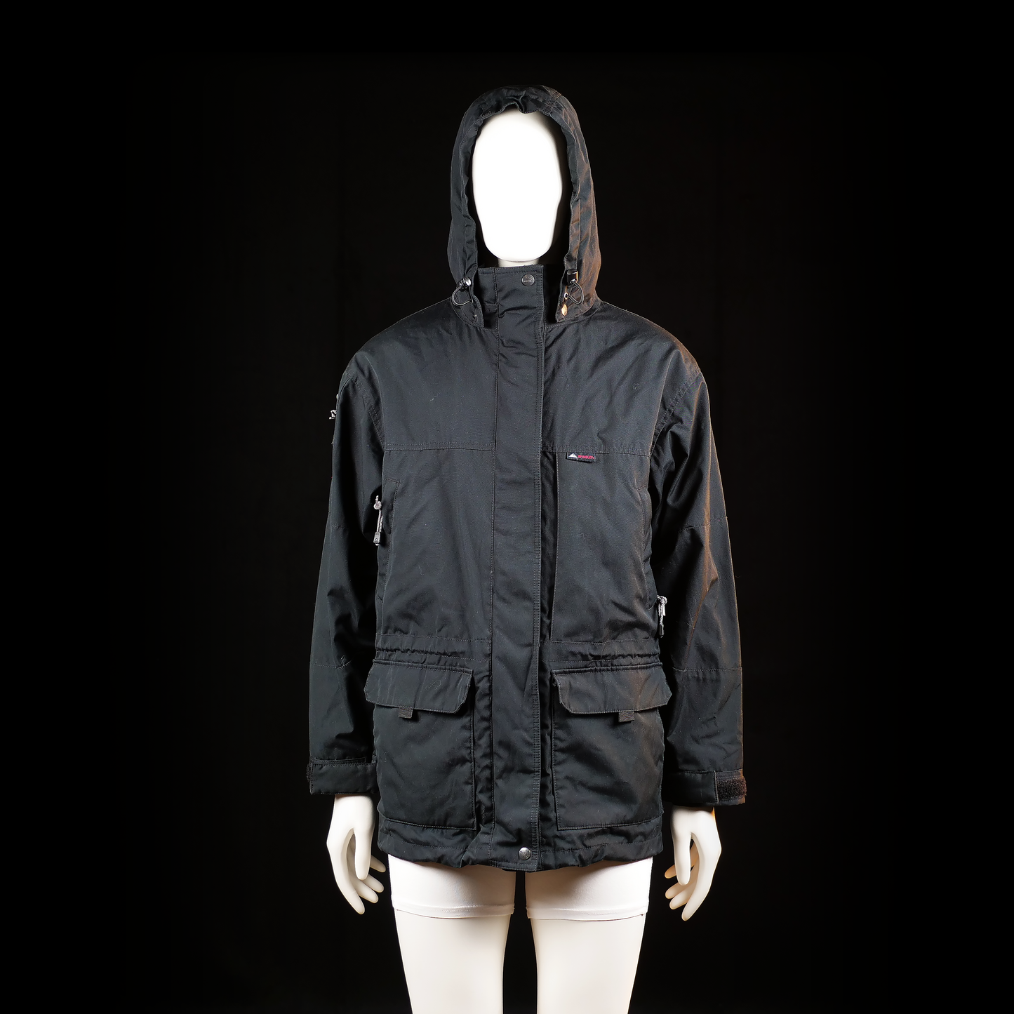 Mckinley - Parka - Black - Size 38 - Hooded jacket with a front zipper and snap closure, featuring adjustable drawcords at the hood and hem. Includes two front flap pockets and zippered side pockets.