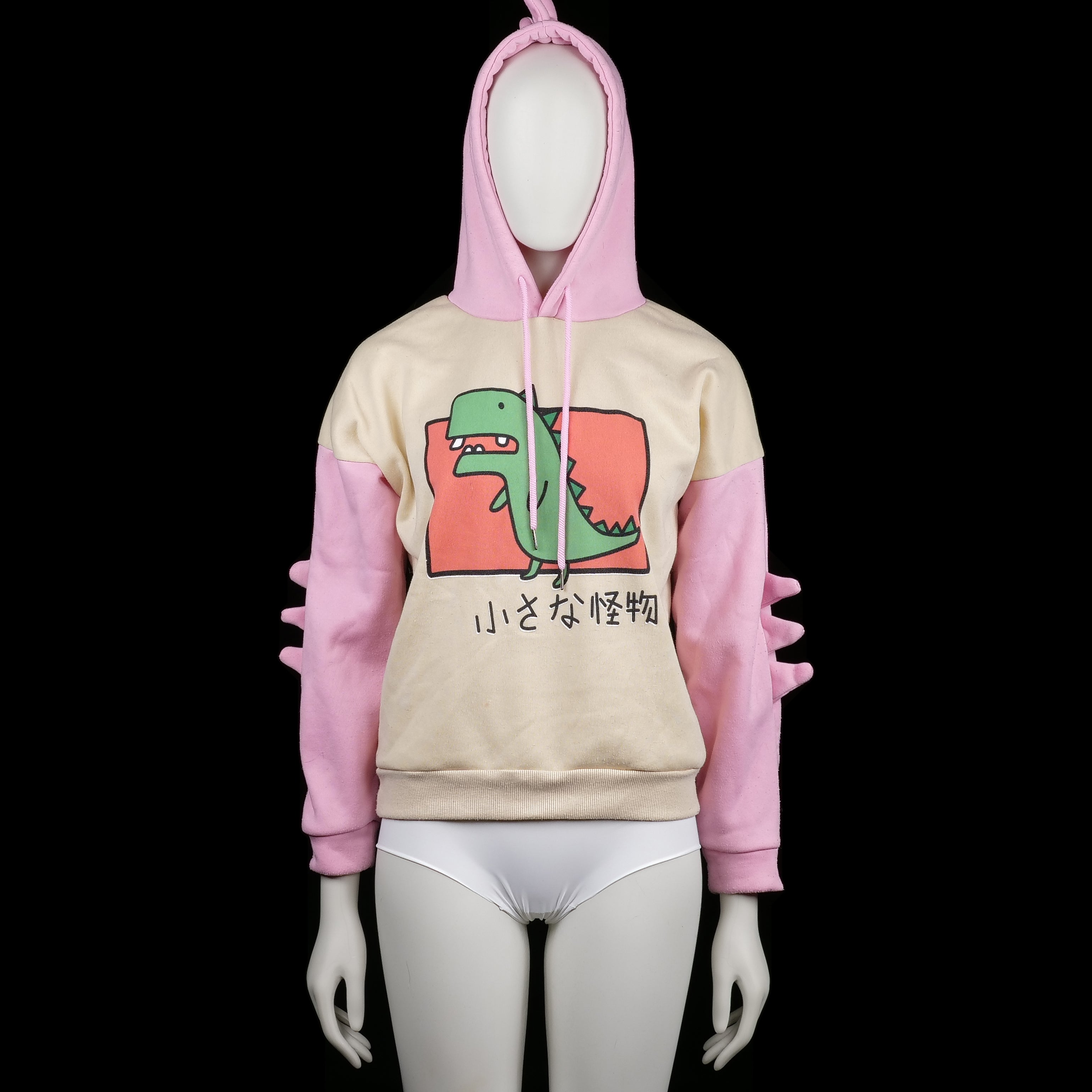 Hoodie - Ivory & Pink - Size S - Two-tone hoodie with ivory body and pink sleeves, featuring a green cartoon dinosaur print on the front and Japanese text. Hood has pink spikes on top and sleeves have matching 3D spike detailing.