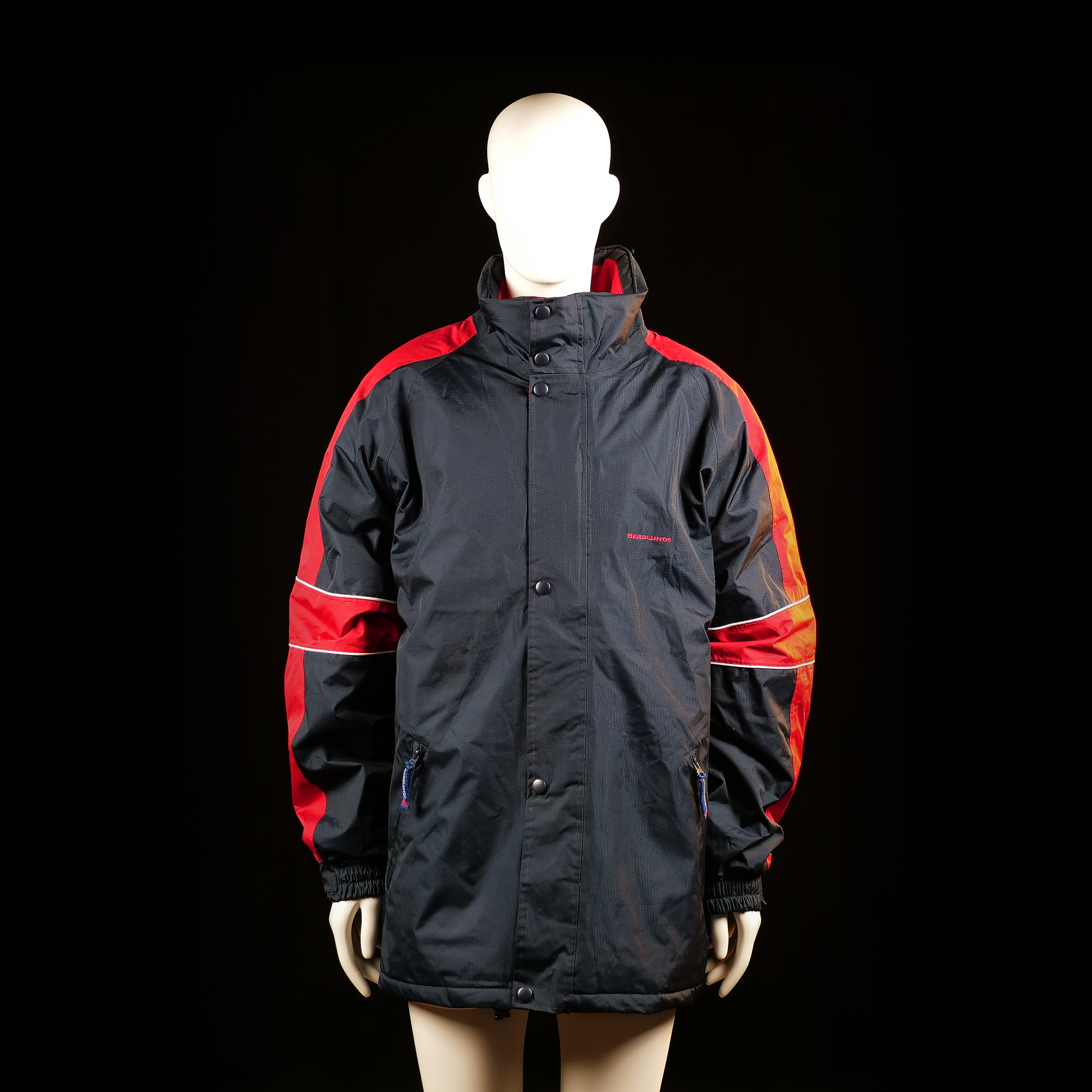 Berglund - Windbreaker - Black & Red - Size 2XL - Long-length jacket with a high collar, front zipper with snap button placket, and elastic cuffs. Features color-block red panels on the sleeves with thin horizontal white piping.